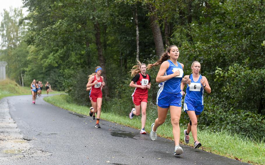 Wiesbaden runners Natalia Bergdorf and Jade Saunders, right, lead a group of runners on their first lap of the 3.1-girls mile cross country race at Vilseck, Germany, Saturday, Sept. 10, 2022.