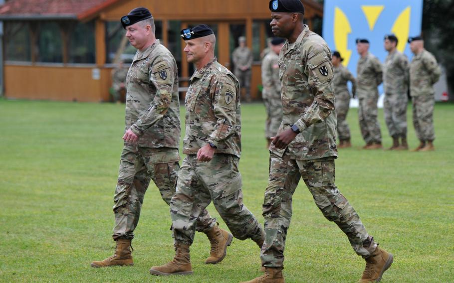 Outgoing commander of the 21st Theater Sustainment Command, Maj. Gen. Christopher Mohan, left, and the incoming commander, Brig. Gen. James Smith, flank U.S. Army Europe and Africa commander Gen. Christopher Cavoli as they march off the field at Daenner Kaserne in Kaiserslautern, Germany, June 8, 2021. 