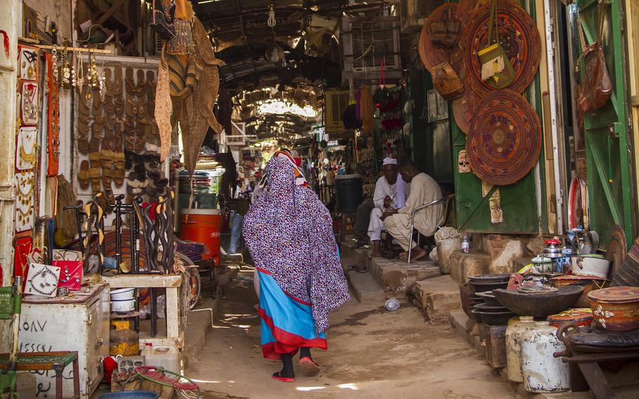 In this undated photo, a woman walks through a market in Khartoum, Sudan. Both sides fighting in Sudan are targeting doctors and activists and silencing the civilian voices seeking to document war crimes and provide services in the face of social collapse, their colleagues said.