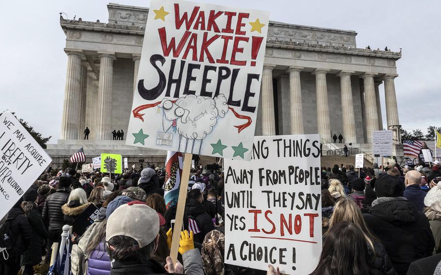 Participants in a rally in opposition to vaccine mandates listen to a speaker at the Lincoln Memorial in Washington, D.C., Jan. 23, 2022.