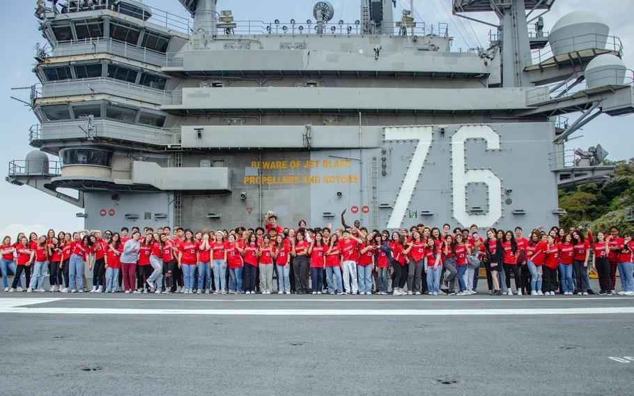 Students from Nile C. Kinnick High School pose for a senior class photo aboard the aircraft carrier USS Ronald Reagan at Yokosuka Naval Base, Japan, April 18, 2023.