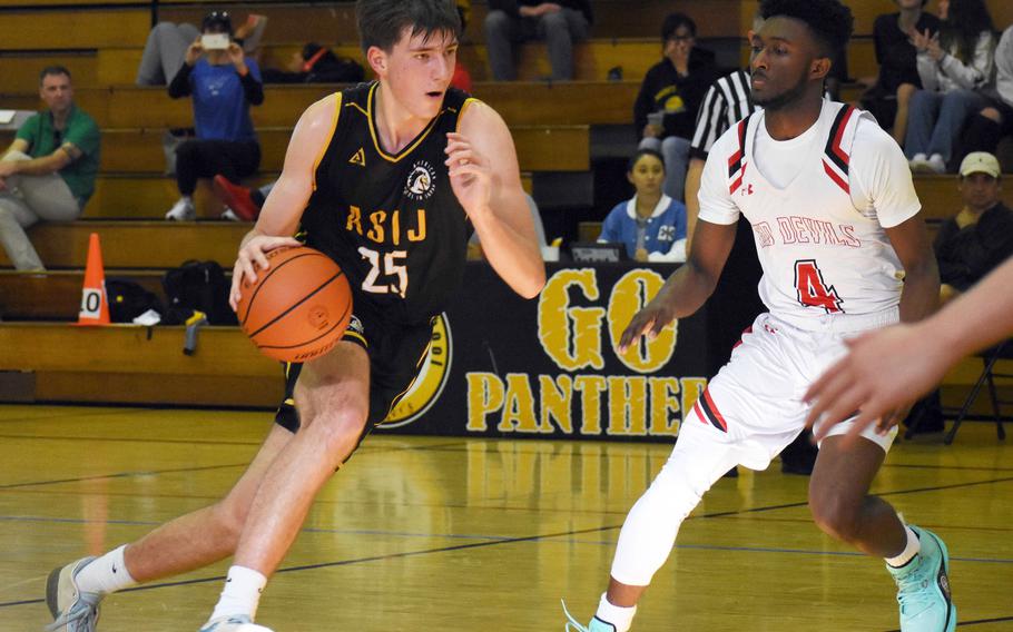 ASIJ's Ayden Carreon dribbles against Nile C. Kinnick's Kennedy Hamilton. The Red Devils won 63-47.