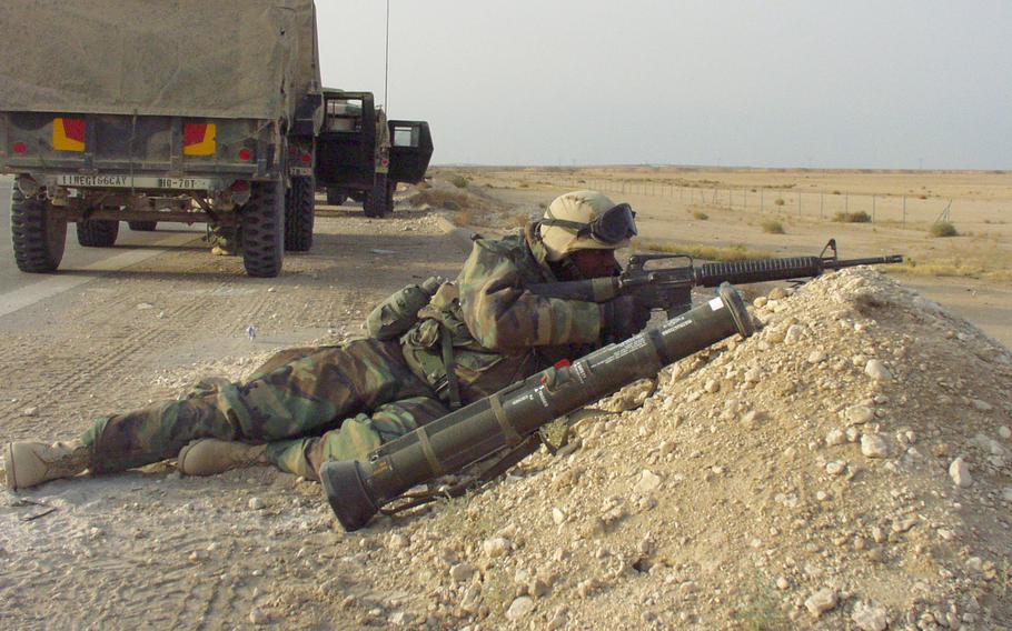 Pfc. Nicholas Wayne Blunt guards the 6th Squadron, 6th Cavalry Regiment's vehicles during a convoy from Camp Udairi, Kuwait, to the unit's new post in central Iraq, in March 2003. Twenty years later, Iran maintains considerable influence over Iraq, and the U.S. still has troops in the country to prevent an Islamic State group resurgence.