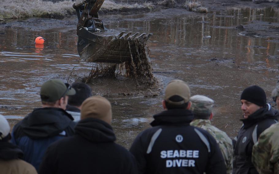 Search crew members sit around the dangerous bog.