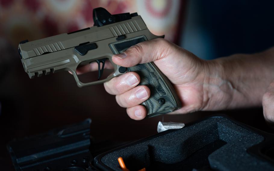 Dionicio Delgado, the Navy veteran from Virginia, holds his P320.