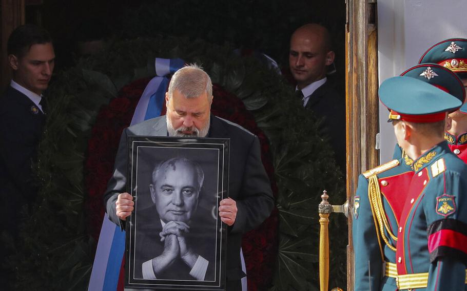 Nobel Peace Prize awarded journalist Dmitry Muratov carries a portrait of the late former Soviet president Mikhail Gorbachev after a farewell ceremony at the Pillar Hall of the House of the Unions in Moscow, Saturday, Sept. 3, 2022. 