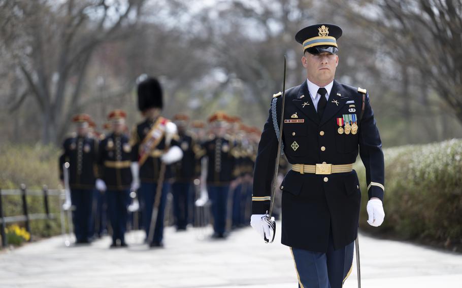 A service member walks down a path