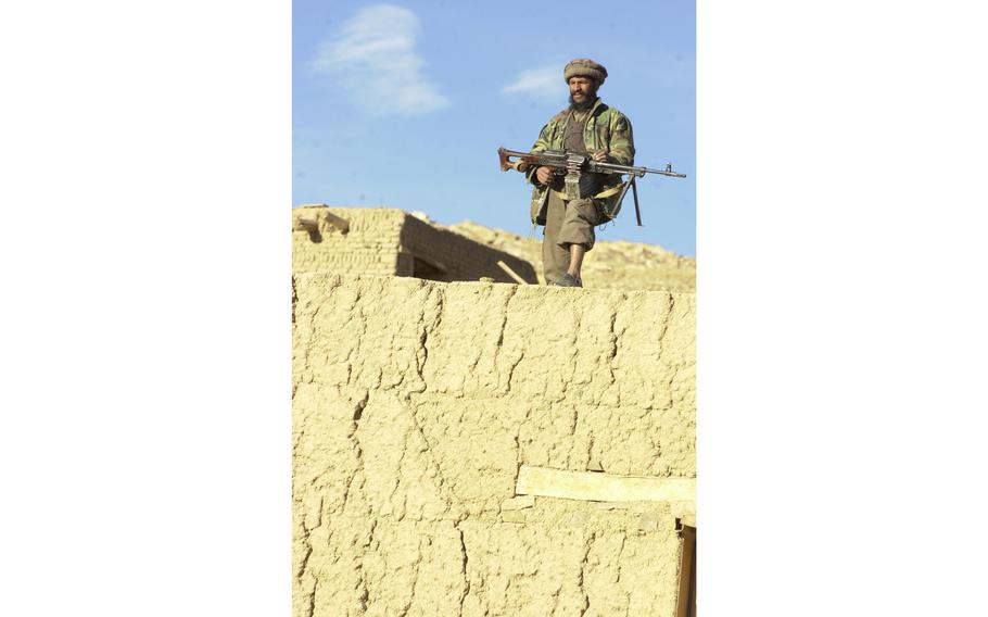 A Northern Alliance machine gunner takes up position just outside the Taliban pocket of Jalreez [Jalrez] as opposition forces pushed towards the village on Nov. 24, 2001.