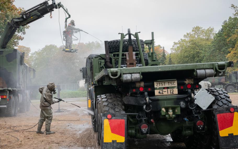 German soldiers pretend to decontaminate U.S. military vehicles during a troop movement demonstration attended by German Chancellor Olaf Scholz outside Cologne, Germany, Oct. 23, 2023.