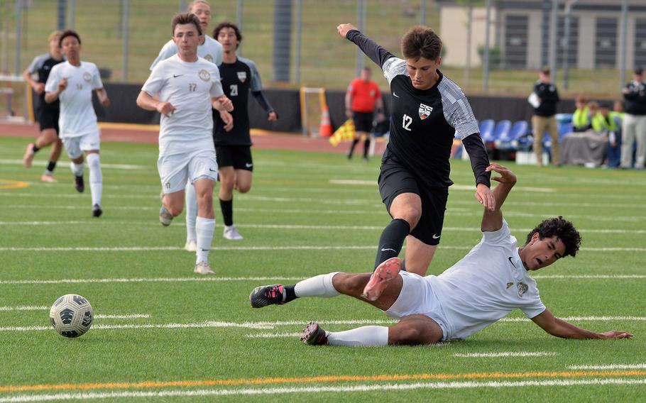 Ramstein’s Caio Anderson slides in to separate Stuttgart’s Seth Harpuder from the ball in the Division I boys final at the DODEA-Europe soccer championships in Ramstein, Germany, May 22, 2025. Ramstein took the title with a 2-0 win.