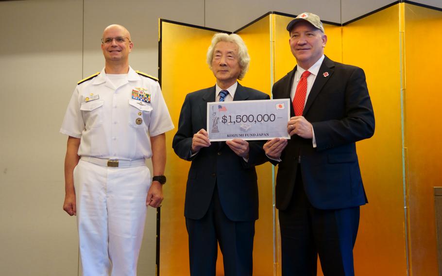 Former Japanese Prime Minister Junichiro Koizumi, center, donates $1.5 million to the American Red Cross in Tokyo, Thursday, July 7, 2022. He is flanked by U.S. Naval Forces Japan commander Rear Adm. Carl Lahti and American Red Cross director Randall Bagwell. 