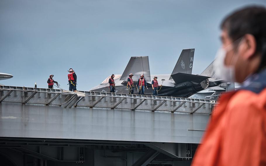 Sailors work aboard the USS Abraham Lincoln upon the aircraft carrier’s arrival at Yokosuka Naval Base, Japan, Saturday, May 21, 2022.