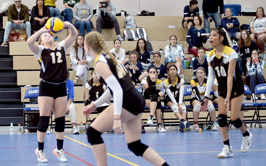 Vicenza’s Larkin Blue, left, sets as a pair of teammates get into position during a match with Aviano at the DODEA European volleyball championships on Thursday at Ramstein High School at Ramstein Air Base, Germany.