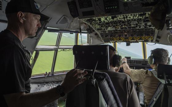 A man stands in the cockpit of his plane.