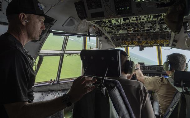 A man stands in the cockpit of his plane.