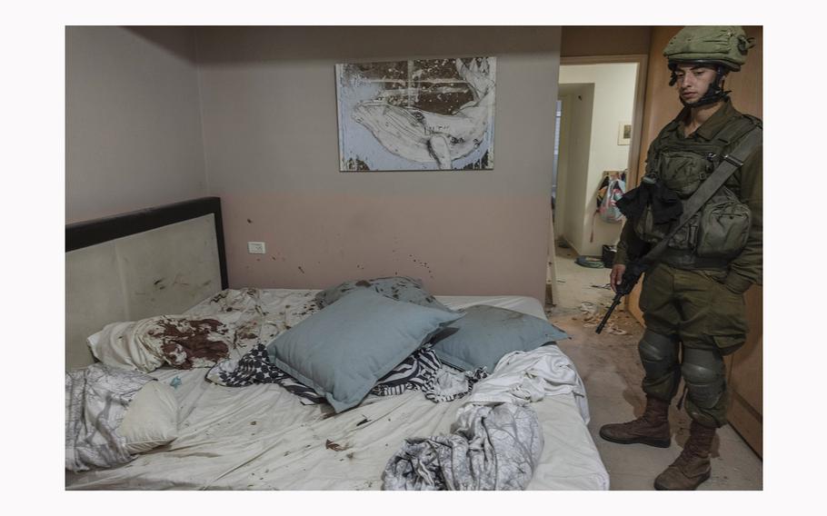 An Israeli soldier looks at a bed stained with blood in a home at Kibbutz Be'eri near the Gaza border where people were killed on Oct. 7, 2023.