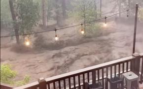 In this image taken from video, flash flooding is seen behind a house in Ruidoso, N.M., Tuesday, July 8, 2025. (Kaitlyn Carpenter via AP)