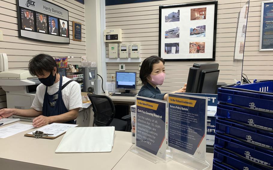 Navy Exchange employees wear masks while working inside a shop at Hardy Barracks in central Tokyo, Friday, May 28, 2021. 