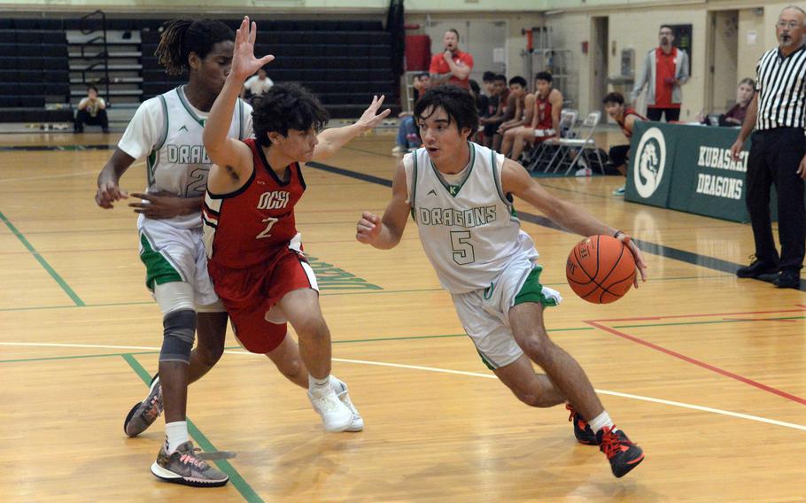 Kubasaki’s Jin Inman drives around an Okinawa Christian  defender during Tuesday’s Okinawa boys basketball game. The Dragons beat the Eagles 66-52.