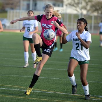 Kadena's Brooke Brewer tries to settle the ball against Kubasaki's Solares Solano during Wednesday's Okinawa girls soccer match. The Dragons won 1-0.