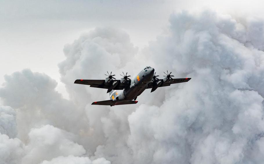 An Air National Guard C-130 out of Reno, Nev., flies over plumes of smoke after dropping fire retardant on the Beckwourth Complex Fire on July 9, 2021 near Frenchman Lake in Northern California. Military aircraft fighting fires this year had the second-busiest season on record since the Modular Airborne Fire Fighting Systems program was established in the 1970s.