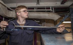 Petty Officer 3rd Class Matthew Johnson, assigned to the aircraft carrier USS Gerald R. Ford’s engineering department, operates a plasma arc waste destruction system Oct. 22, 2022. The system incinerates trash at over 9,000 degrees Fahrenheit.