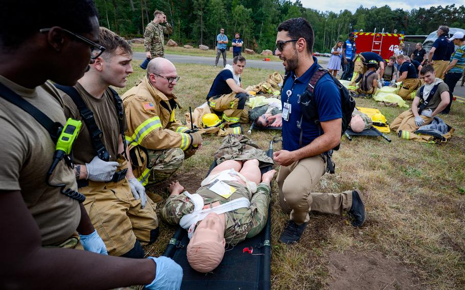 Firefighters with the 86th Civil Engineer Group receive feedback from Naciri Mehdi, a medical simulation specialist assigned to Landstuhl Regional Medical Center, during a simulated aircraft crash scenario during Operation Varsity, a recurring emergency exercise at Ramstein Air Base, Germany, July 26, 2022.