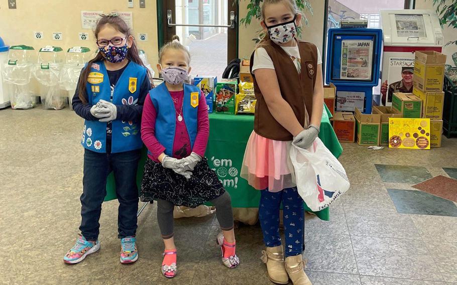 Left to right: Girls Scouts Avalynn Mendoza, 7, Korra Warner, 6, and Aurora Warner, 8, pose while selling the organization's famous cookies at Yokota Air Base, Japan, Feb. 5, 2022.