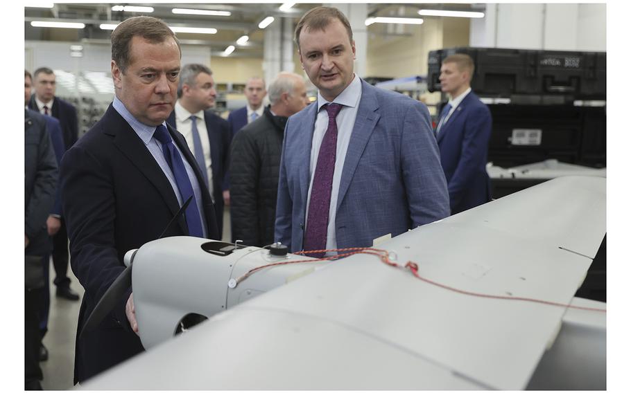 Russian Security Council Deputy Chairman Dmitry Medvedev, left, and Nikita Morshchakin, the head of the unmanned aerial vehicle production of the Special Technology Center, look at a drone in St. Petersburg, Russia, on Oct. 14, 2022. 
