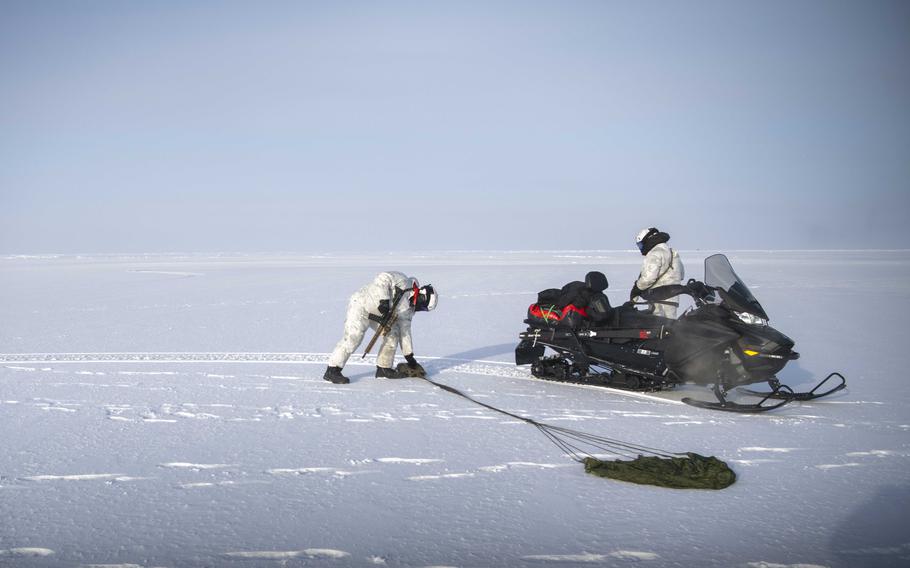 Navy SEALs and Norwegian naval special operations commandos retrieve an airdropped package from a C-130 Hercules assigned to the New York Air National Guard’s 109th Airlift Wing during exercise Arctic Edge on Saturday, March 9, 2024. The training was designed to bolster troops’ skills in an arctic environment.