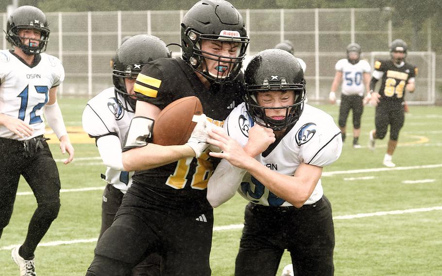 American School In Japan's Oskar Vermiere gets wrapped up by two Osan defenders.