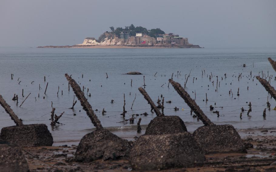This picture taken Dec. 5, 2023, shows Taiwan’s remote Shihyu islet, as seen from behind the the anti-landing spikes on Taiwan’s frontline island of Little Kinmen. Spikes jut from the beaches of Taiwan’s Kinmen island, military checkpoints serve as traffic roundabouts and bunkers double up as tourist cafes — reminders everywhere of the conflict decades earlier with Chinese communist forces.