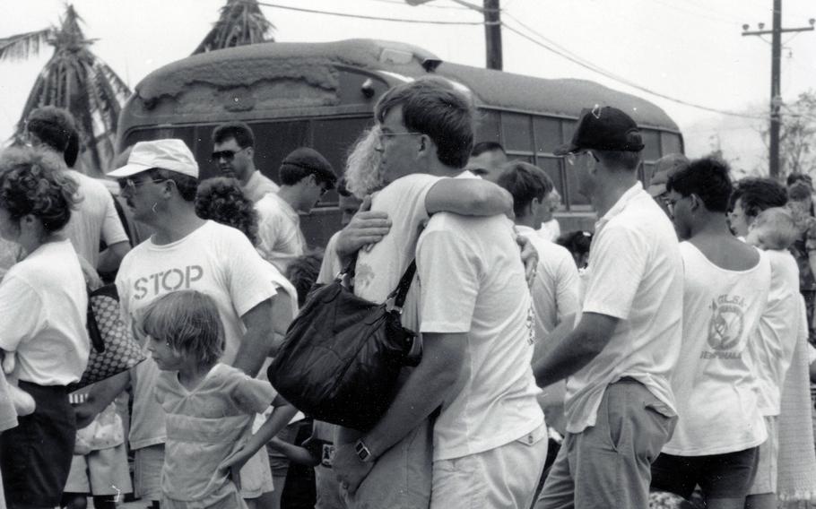 Mark Hanneman hugs his wife, Susan, shortly before she and their daughter Sarah, left, were evacuated from Naval Station Subic Bay due to the eruption of Mount Pinatubo in the Philippines, in June 1991. 