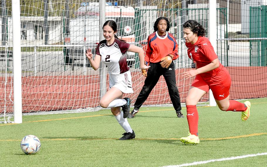 Vilseck's Arianna Almanza and Kaiserslautern's Michela Figuera chase after a ball during the first half of the Falcons' and Raider's match Saturday morning at Kaiserslautern High School in Kaiserslautern, Germany. In the background is Vilseck goalkeeper Nyja Flournoy.