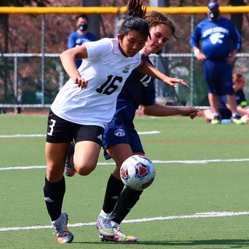 Daegu’s Leah Williamson and Osan’s Riley Hunt battle for the ball during Saturday’s DODEA-Korea girls soccer match. The Warriors won 3-2.