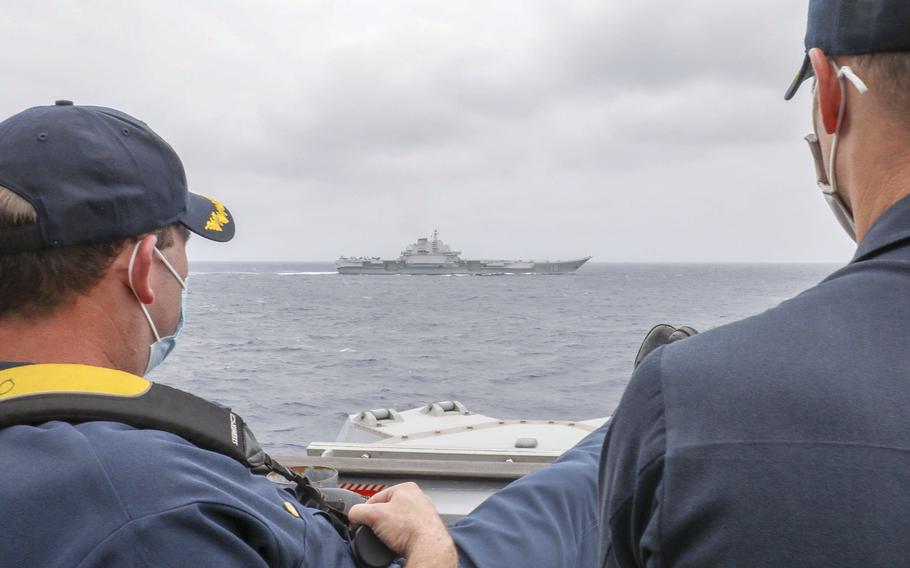 Sailors aboard the guided-missile destroyer USS Mustin monitor the Chinese aircraft carrier Liaoning as it steams through the Philippine Sea, April 4, 2021.