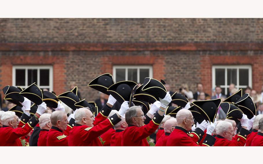 Chelsea Pensioners raise their hats as they offer three cheers for Britain’s Queen Elizabeth II, as they take part in their Founders Day parade in London, Thursday, June 7, 2012. The Royal Hospital Chelsea has been caring for Britain’s veteran soldiers since its foundation by King Charles II in 1682, the veterans known as Chelsea Pensioners are easily identifiable by their traditional red coats. 