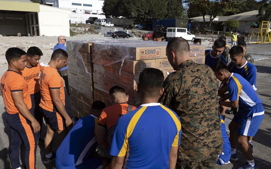 U.S. Marines and Filipino troops load relief supplies at Villamor Air Base in Pasay, Philippines, Feb. 11, 2024.