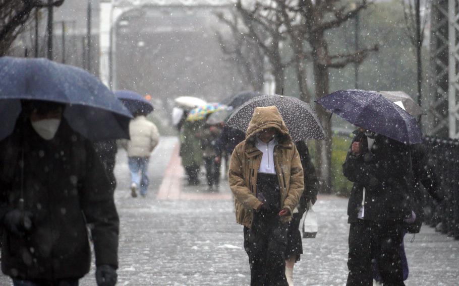 Snow begins to fall on commuters in Yokohama, Japan, Monday, Feb. 5, 2024.