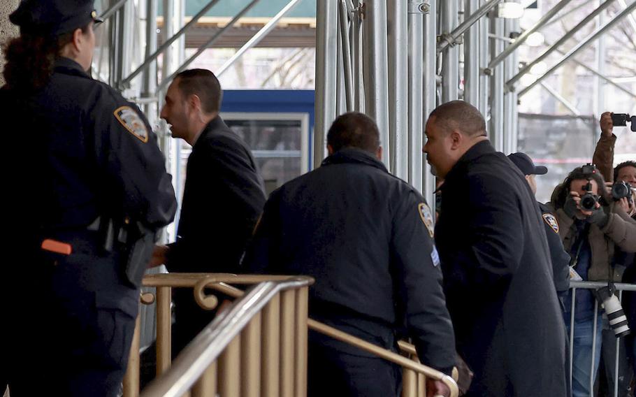 Manhattan District Attorney Alvin Bragg is escorted by his security detail while arriving at his office early Wednesday morning, March 22, 2023, in Manhattan. 