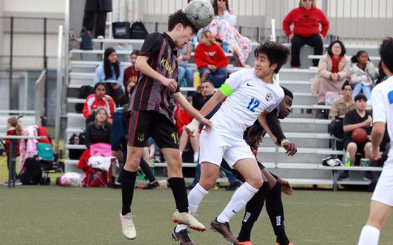Nile C. Kinnick's Luis Galloway heads the ball in front of Christian Academy Japan's Christopher Kinoshita. The Red Devils won Tuesday's Kanto Plain boys soccer match 7-1.