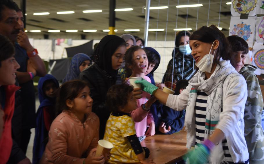 Madina Fahim, 15, who fled Afghanistan with her family, hands out cups of tea and formula at Rhine Ordnance Barracks, Germany, in September 2021. Afghans seeking special immigrant visas are again being brought to the Kaiserslautern Military Community in Germany, the first time that's happened since 2021.