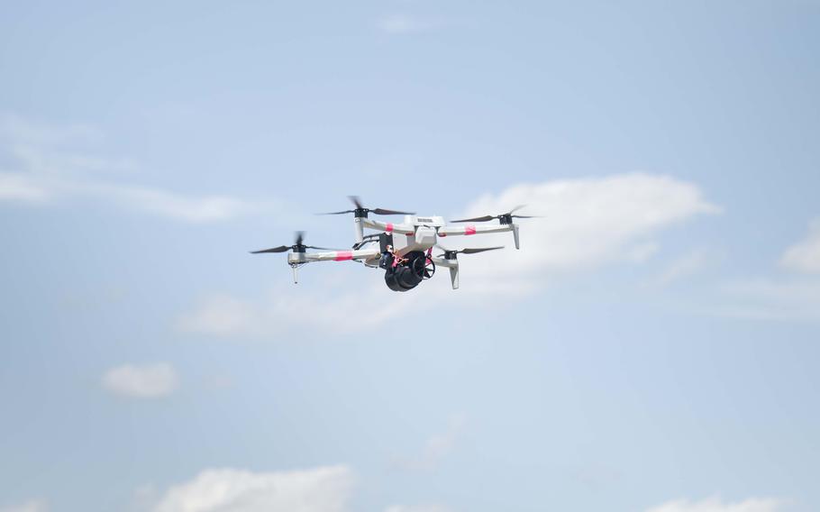 A Skydio X10D drone takes flight with a dummy M67 grenade round.