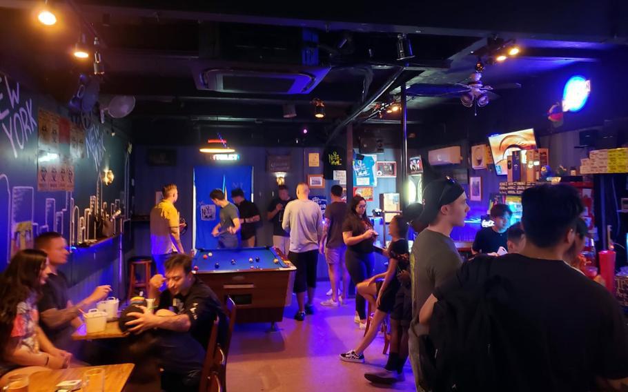 U.S. service members and others hang out at a bar near Yokosuka Naval Base, Japan, June 22, 2021. 