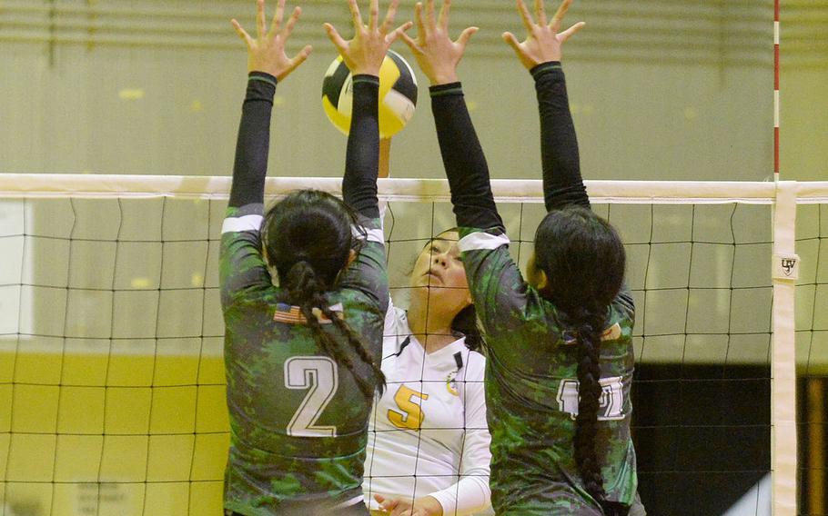 Kubasaski's Runa Holladay and Ayeli Rocha go up to block Kadena's Haide Alvarez for the match-winning point in Tuesday's Okinawa volleyball match. The Dragons won in five sets to level the season series 1-1.