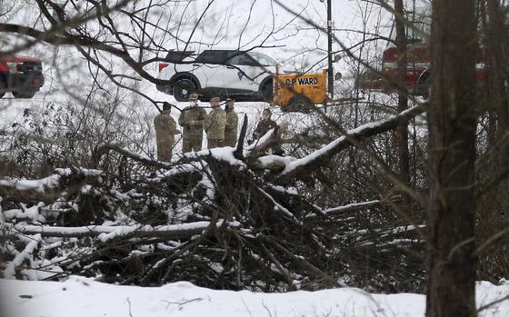 Investigators confer near the wreckage of a UH-60 Black Hawk medical evacuation helicopter in a field in Mendon, NY., Thursday, Jan. 21, 2021. Three National Guard members were killed in the crash on Jan. 20. Officials say human error caused the crash of the Army National Guard helicopter during a January training exercise in upstate New York. (Jamie Germano/Democrat & Chronicle via AP)