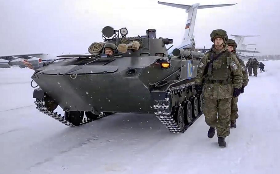 A video screen grab shows Russian peacekeepers walking next to their military vehicle as they exit a Russian military plane at an airport outside Ivanovo, Russia, on Jan. 15, 2022, after returning from a deployment to Kazakhstan.
