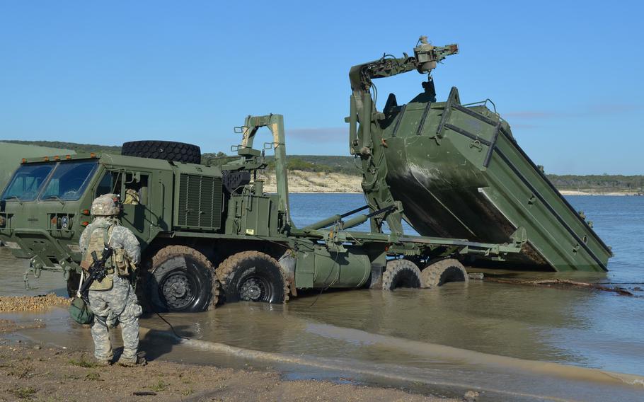 Soldiers lower a bridge building boat into the Belton Lake at Fort Cavazos, Texas, as part of a division-level training exercise Nov. 3, 2023. 