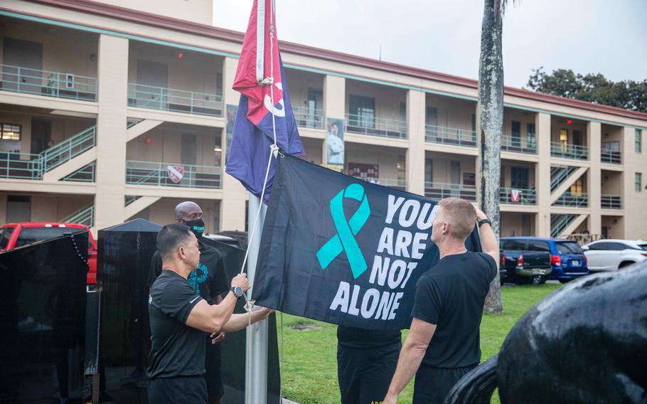 Col. Josh Bookout, 3rd Infantry Brigade Combat Team, 25th Infantry Division commander, and Command Sgt. Maj. Thinh Huynh, 3rd Infantry Brigade Combat Team, 25th Infantry Division, add a flag with the words, ”You Are Not Alone” to the brigade flagpole to kick off the annual Sexual Assault Awareness and Prevention Month at Schofield Barracks, Hawaii, in 2021. 