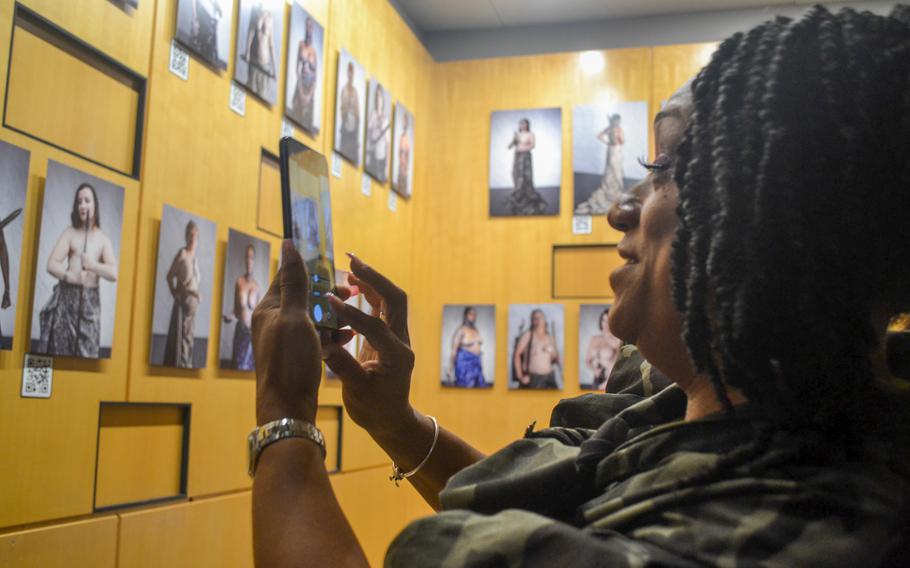 Army veteran Tamekiah Aguirre takes a photo of her portrait at the Military Women’s Memorial at Arlington National Cemetery, Va. Aguirre had her portrait taken in July. Aguirre had followed photographer Charise Isis’ Grace Project for a couple of years before her breast cancer diagnosis in September 2020. As part of The Athena Division, a military chapter of the Grace Project, female veterans impacted by breast cancer were photographed. 